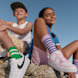2 kids sitting on rock with sneakers